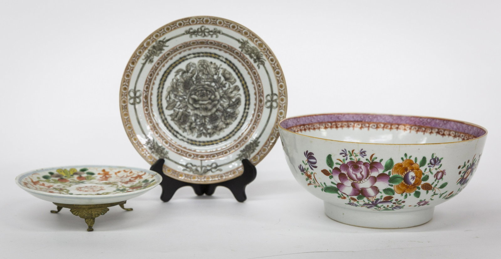 Chinese Porcelain: Lot of three, including a famile rose fruit bowl with floral polychrome enamel decoration circa 1810, made for export market, 10 1/8" diameter x 4 1/2" high; plus underplate on ormolu mount with blue 