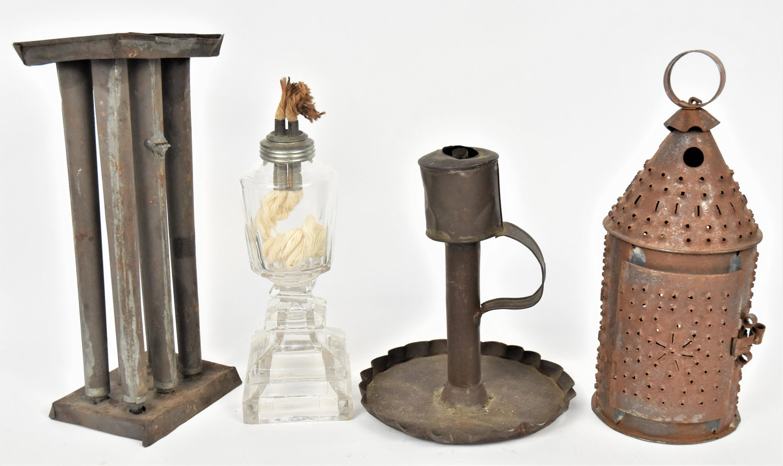 Early Lighting Lot: Lot of four, including a six tube tin candle mold, 4 1/2 x 3 1/2 x 10" high; plus tin whale oil camber lamp with C scroll handle and ruffled tin base, 6" diameter x 7 1/2" high; plus smaller tin Rever