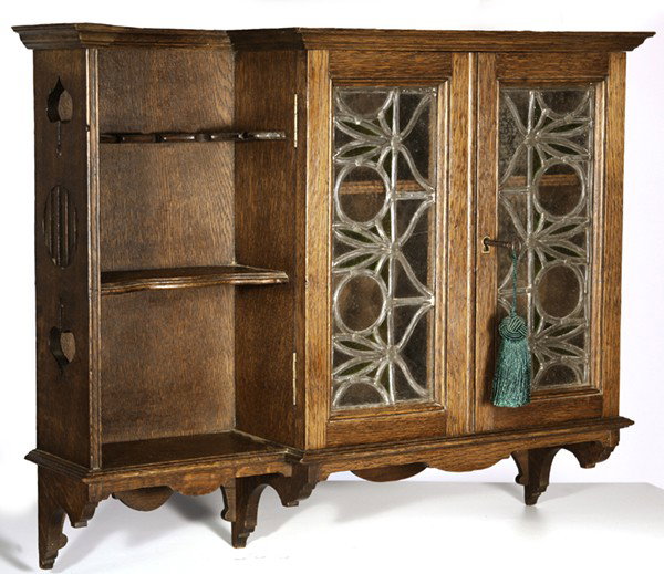 ARTS & CRAFTS HANGING CABINET: With leaded glass doors and cut-outs; original medium brown finish. Very good condition. 21" H x 25" W x 6 1/2" D.