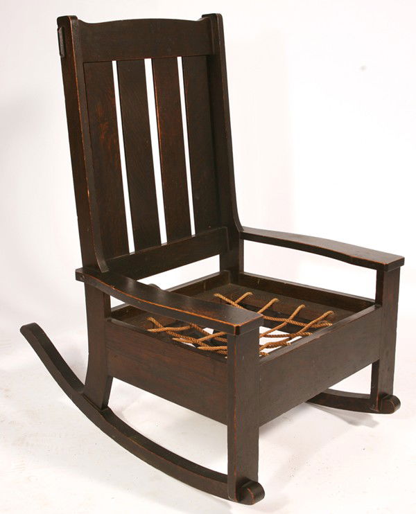 EARLY LIMBERT ROCKER #802 3/4: With four slat back; excellent original dark finish; original seat support. Unsigned. Cushion missing. Excellent condition. 36" H x 24 1/2" W x 31 1/2" D.