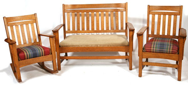 ARTS & CRAFTS 3-PC. SET: Including drop arm settle with 12-slat back; thru-tenon arms and long corbels. Arm chair with 5-slat back; thru-tenon arms and long corbels. Rocking chair with 5-slat back; thru-tenon and long corbels