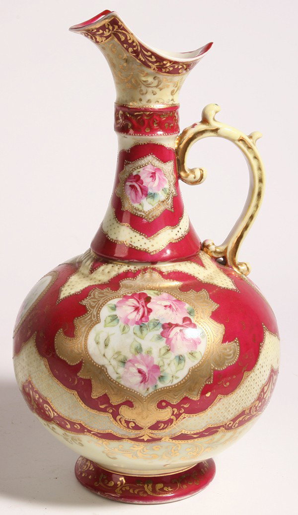 LG. NIPPON EWER: Decorated with panels of painted roses on red ground with gilt highlights. Unmarked. 13" high.