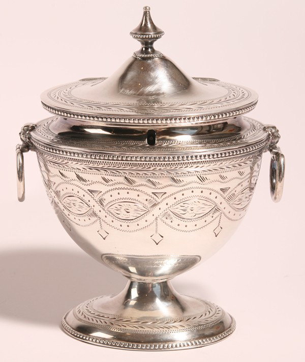 FINE SHEFFIELD SILVER URN FORM TEA CADDY: In the Adams style with grotesque mask ring handles, marked on base, with lock and divided interior. 8" high. Excellent, lacks key.