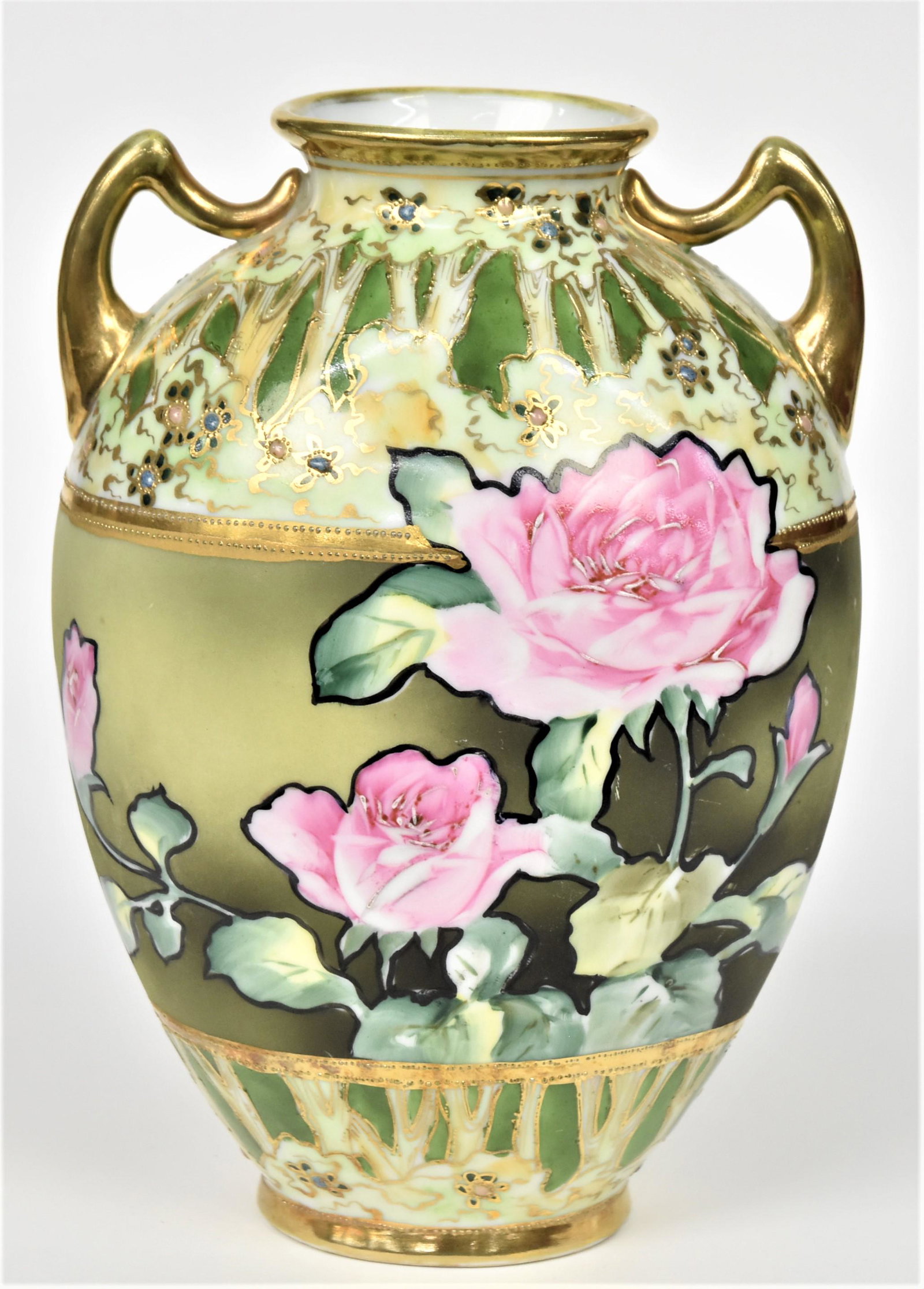 Nippon Handled Vase: Pink roses front and back in panel. Forest decorations at shoulder and base accented with jeweled wild flowers. 8 3/4" tall. Maple leaf backstamp. Handsome and in good condition.
