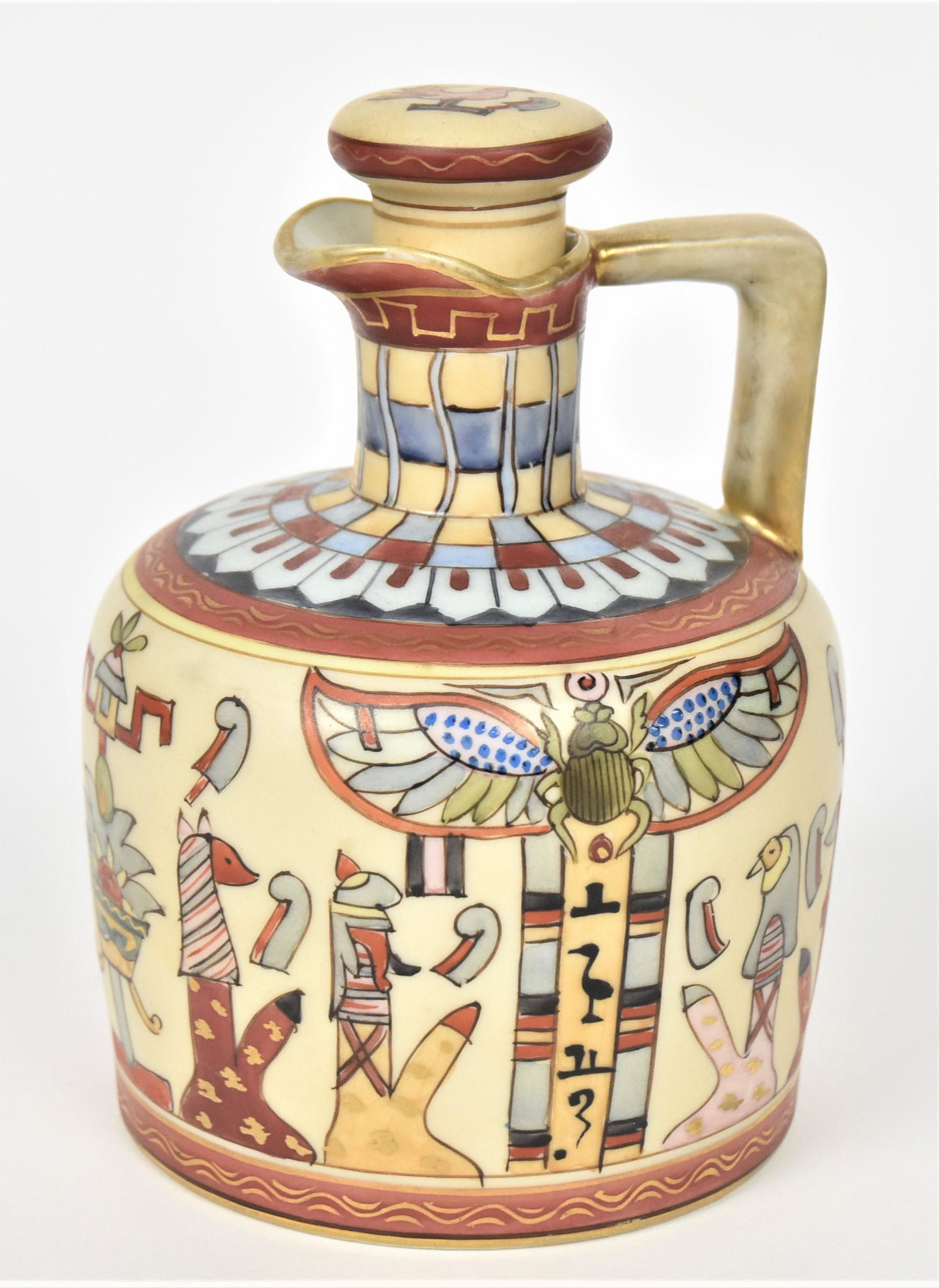 Nippon Egyption Whiskey Jug: All over designs including a winged beetle. 6 1/4" tall, 4"diameter. M in wreath backstamp, good condition.