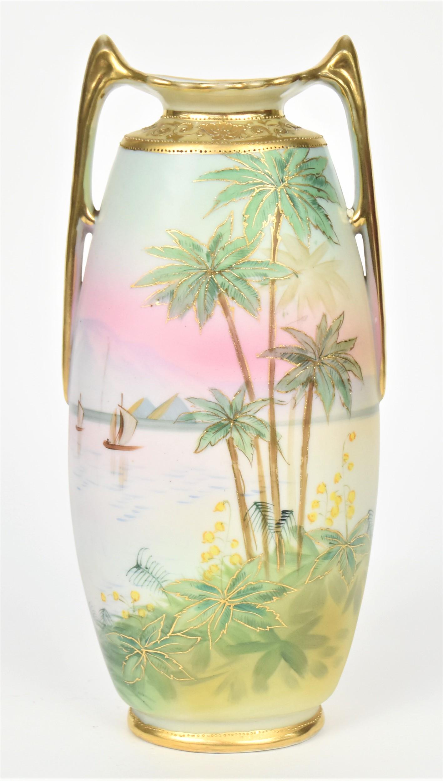 Nippon Scenic Handled Pillow Vase: With palm trees, sailing vessels on a lake and pyramids on the horizon. Raised gold trim on neck. 10 1/4" tall. Good surround scene, M in wreath backstamp. Good Condition.