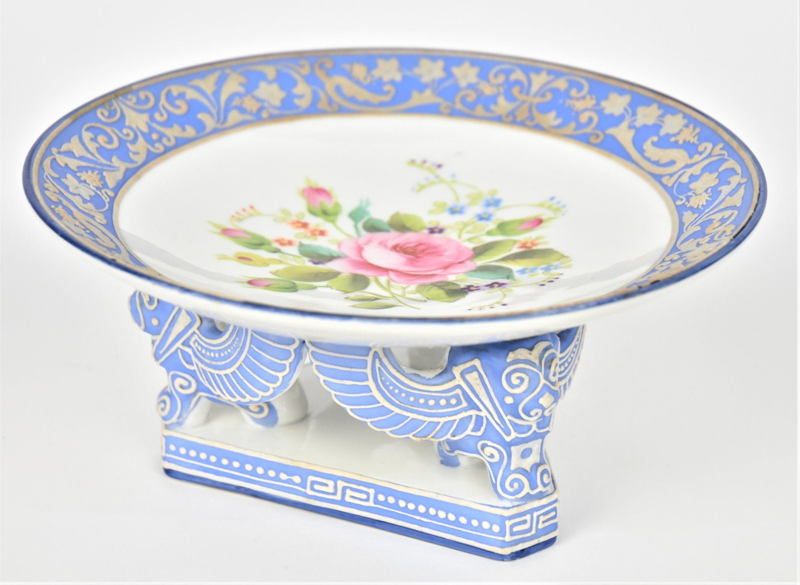 Nippon Wedgewood Moriage Compote: Centered with Dresden-styled floral bouquet. Nice decorative border. Three blue griffens accented with enameling loft the tray. 3 1/2" t all and 7 3/4" diameter. M in wreath logo. Good condition.