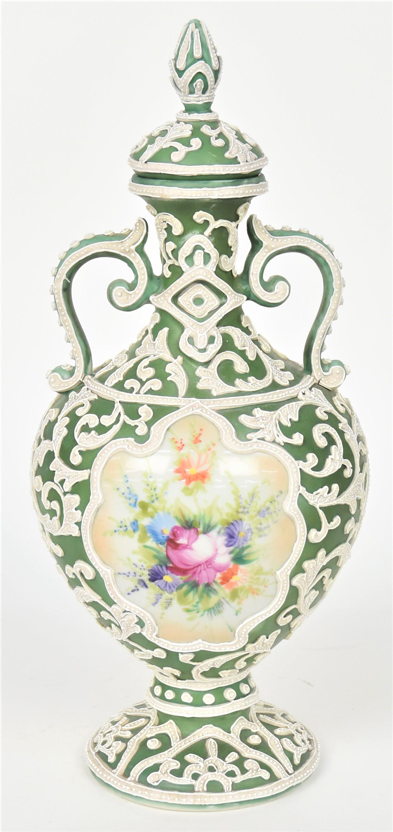 Nippon Moriage Covered Urn: Wonderful scrolled ferns surround two ovals and two diamond forms containing dresden style floral bouquets. 11" tall, 5 1/4" across body. Unmarked. Repair to stoppers insert and a bead missing at pain