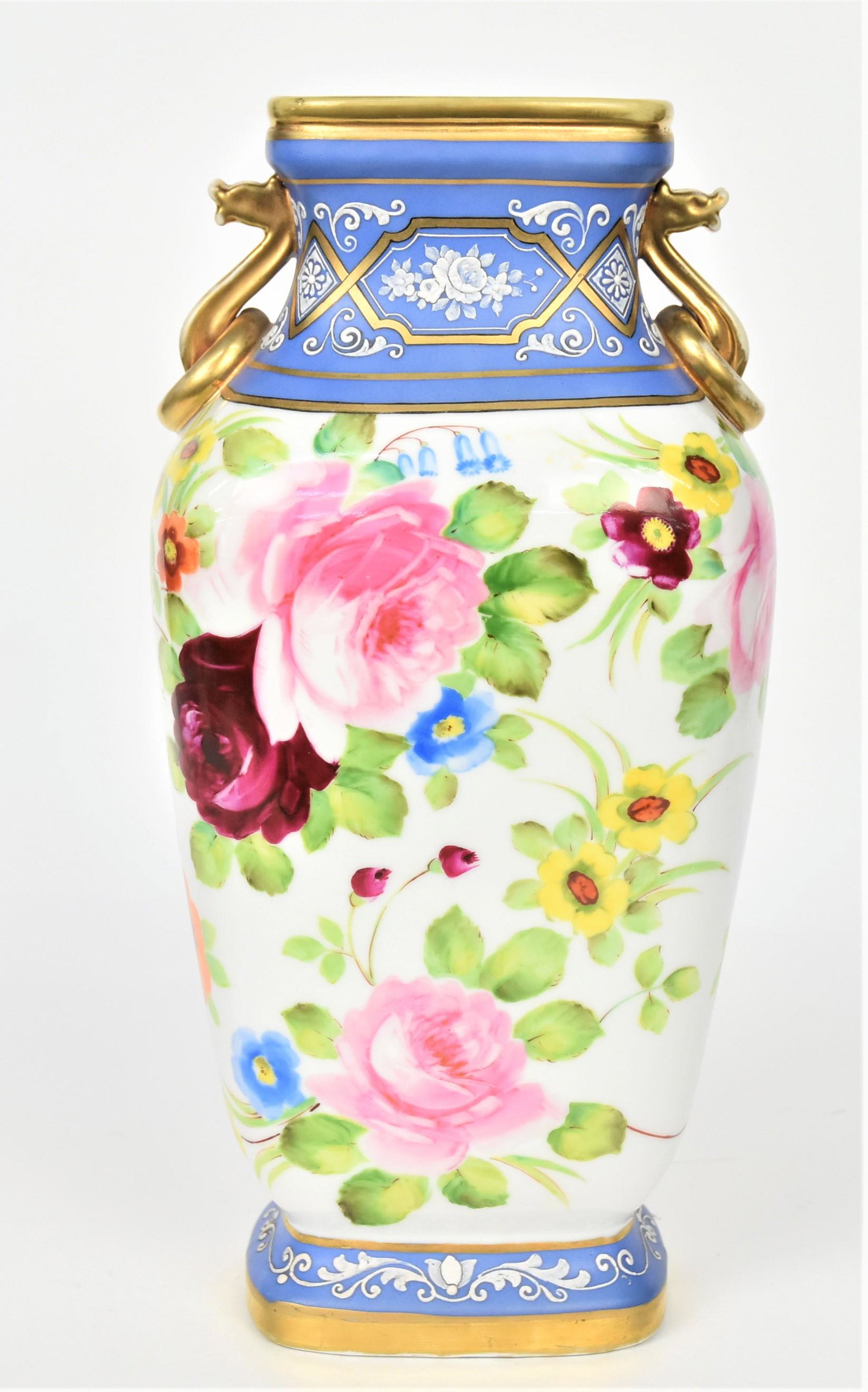 Nippon Wedgewood Squared Vase: Beautiful delicate floral and scroll enamelling on blue. Colorful dresden sytle blossoms scatter the body. Gold dragon head handles with stationary rings. 12"tall, 6" across shoulder. M in wreath logo