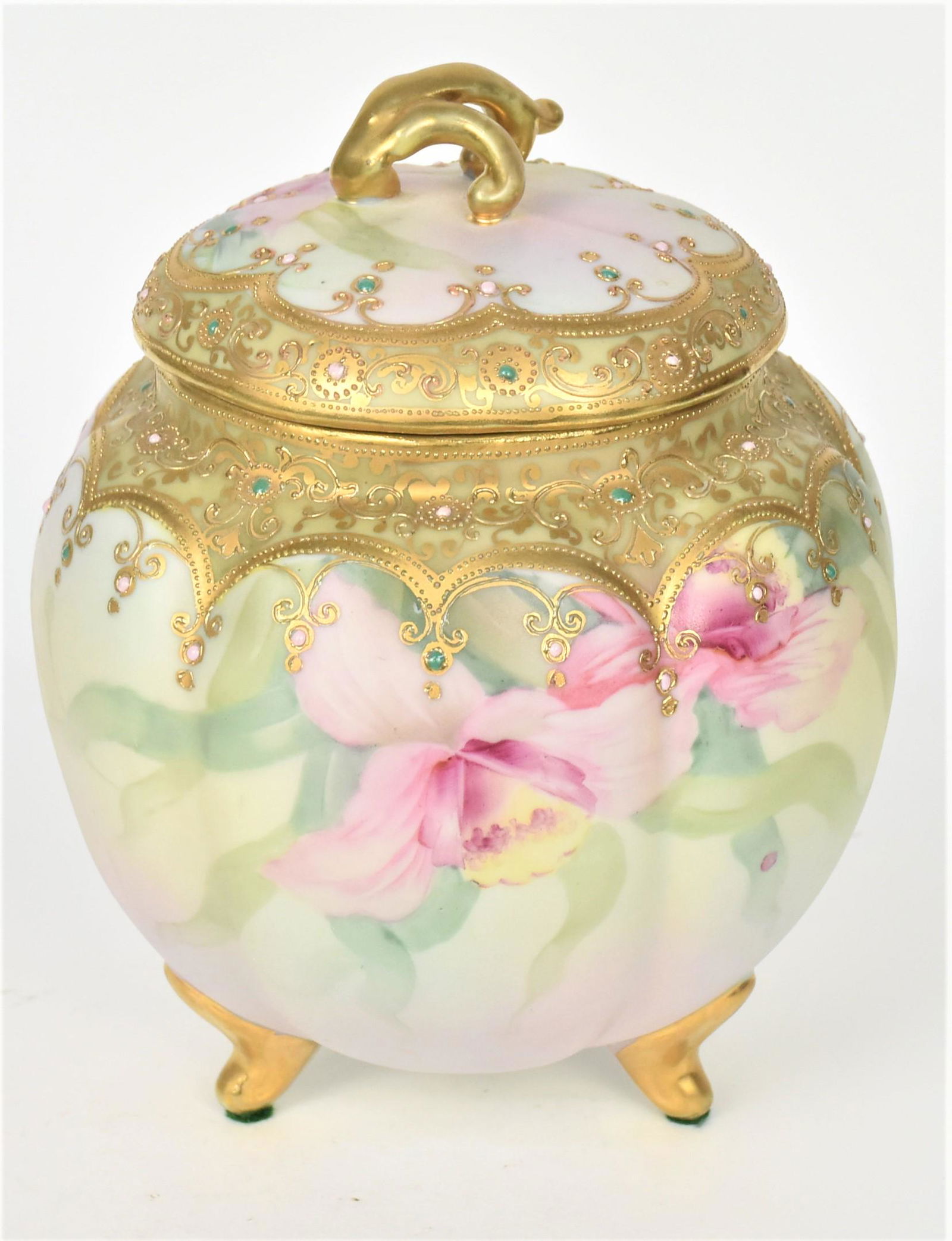 Nippon Jeweled Orchid Cracker Barrel: With three gold feet lifing a melon ribbed container. Fanciful raised gold and jeweled trim, 8" tall. Maple leaf logo. Attractive and in good condition.
