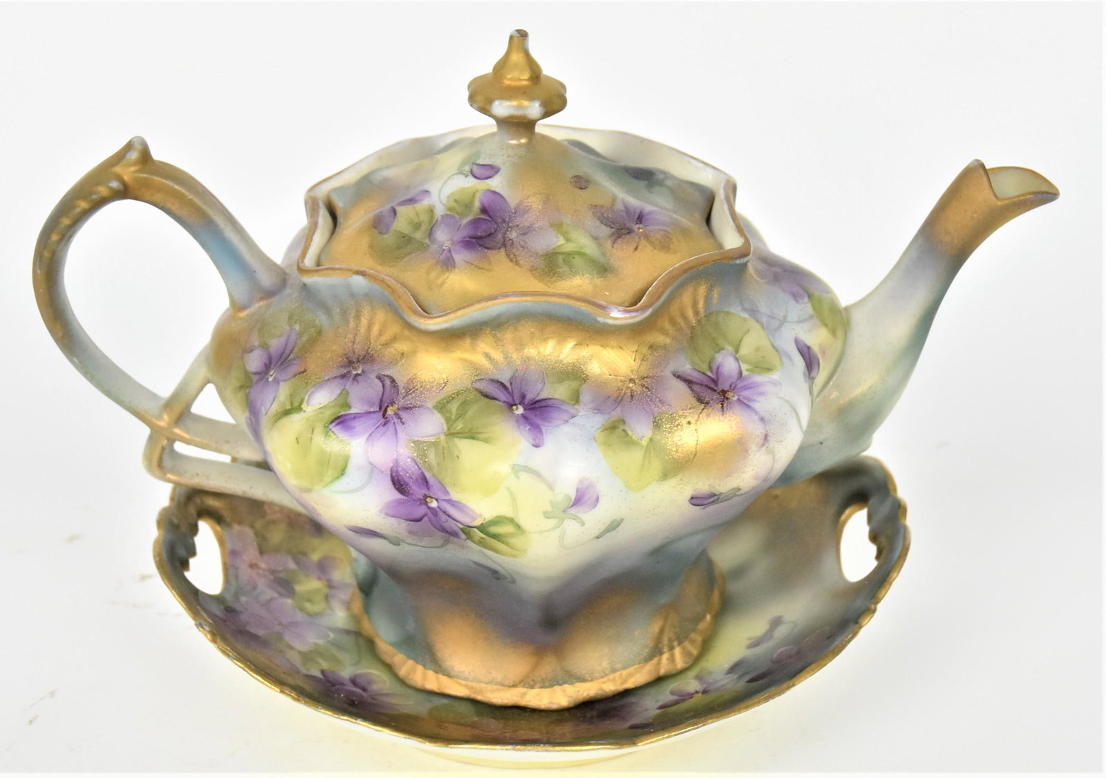 Nippon Individual Teapot and Candy Dish: Featuring sweet violets and sponged on gold. 5 1/2" teapot, tray with faint 1" hairline on rim. Both maple leaf logo