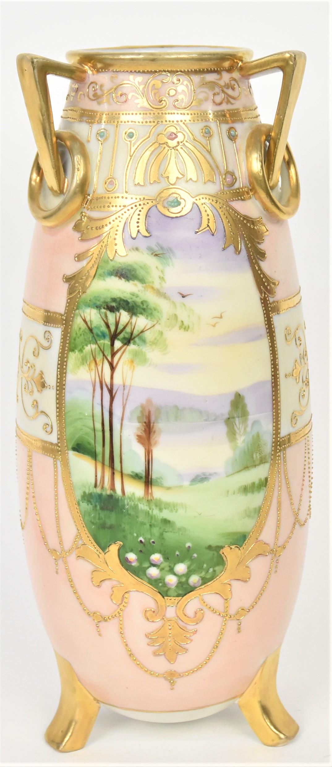 Nippon Jeweled Scenic Vase: Featuring triple gold handles with stationary rings and tri-footed base. Summer coastal scenes front and back. Attractive raised gold necklaces and designs. 11 1/4" tall, M in wreath logo. Highly deco