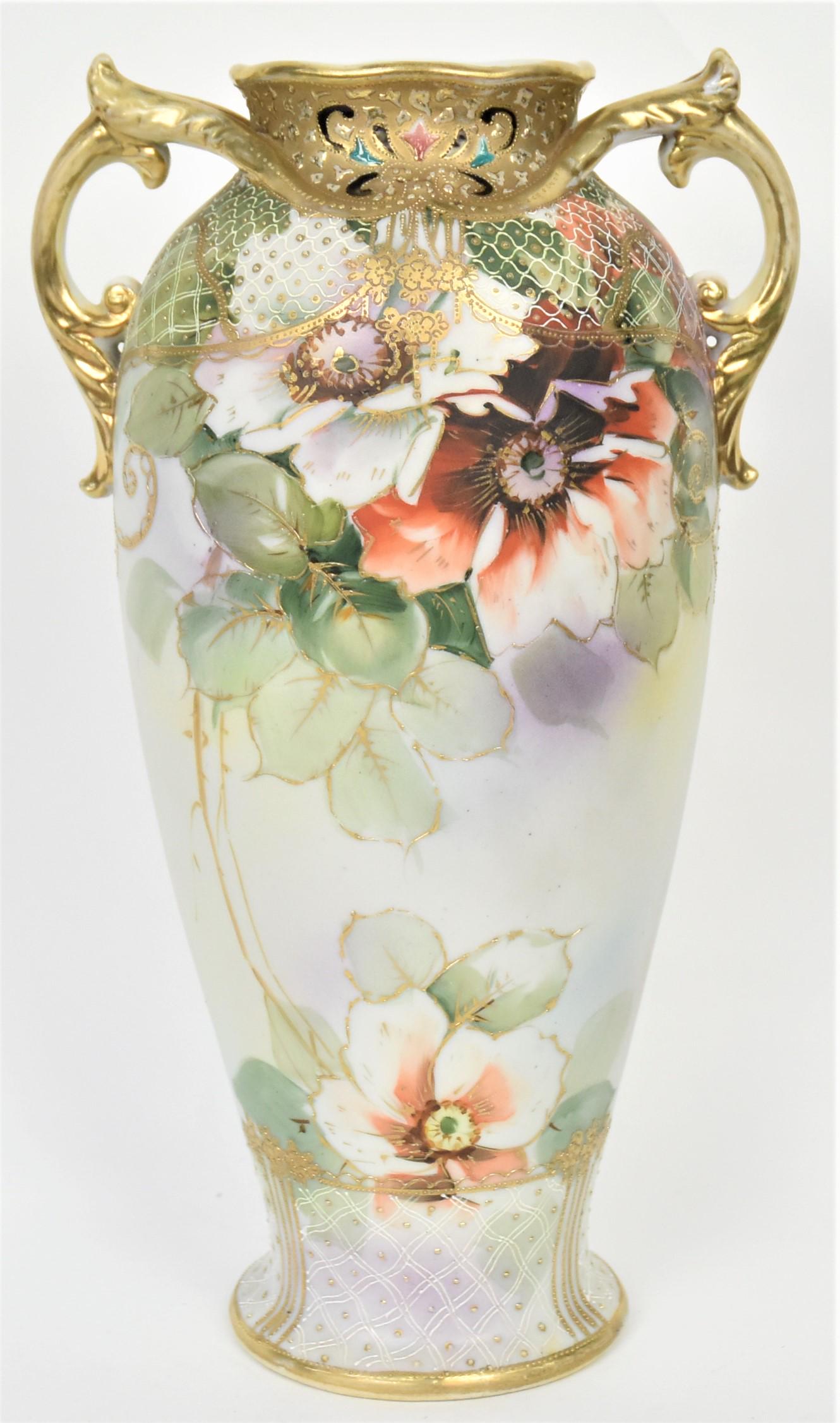 Imperial Nippon Jeweled Vase: Ornately decorated with enameled netting and multi-colored jewels on shoulder and base. Oversized painted wild roses in between leaf scrolled molded double handles, 11 1/2" tall. Imperial Nippon logo,