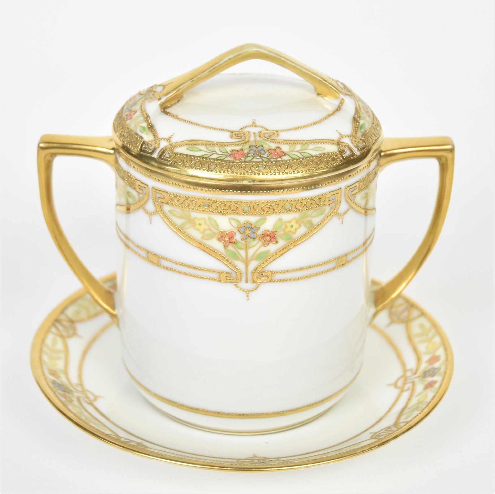 Nippon Three Piece Condensed Milk Container: Delicate and colorful floral and raised gold borders. Consisting 5 1/4" covered and handled container with factory hold in bottom to retrieve jelly jar. Matching undertray, 6" diameter has RC Nippon L