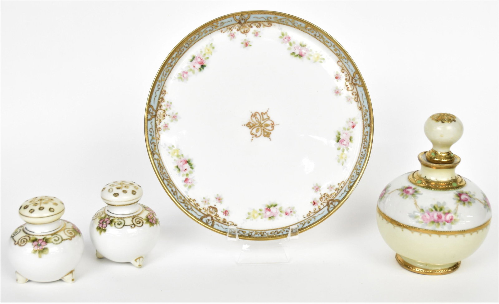 Four Nippon Items: Stoppered perfume, 5" tall and 7" diameter tray. Each have baby rose decorations and M in wreath logos. Plus Salt and Pepper shakers with raised gold and floral design, 2 1/2" tall, Good condition.