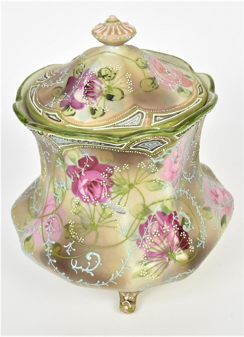 Nippon Moriage Floral Covered Cracker Barrel: Featuring scattered rose blossoms overlaid with enameled green Annes lace and scrolled forms. Triple acanthus leaf feet, 8"tall. Maple Leaf logo. Highly attractive and in very good condition.