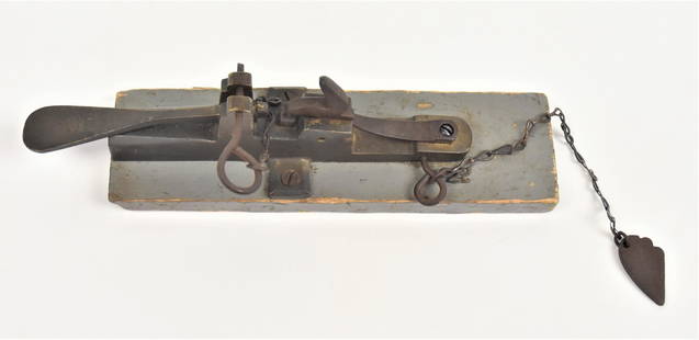 Brass Percussion Trap Gun: Brass circa .25 caliber with 3" long barrel marked on right side 665, mounted on gray painted wood board, 9 1/2" long. These weapons were used to kill animals, some have suggested they were also used