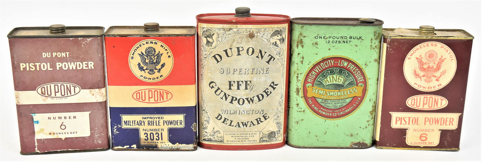 Five Black Powder Tins: Including chromoithographed example, oval King Powder Co. Semi-Smokeless with threaded lid on green field, 4 x 1 3/8 x 6" high; plus oval Dupont Superfine FFF Gunpowder lithographed paper label on red