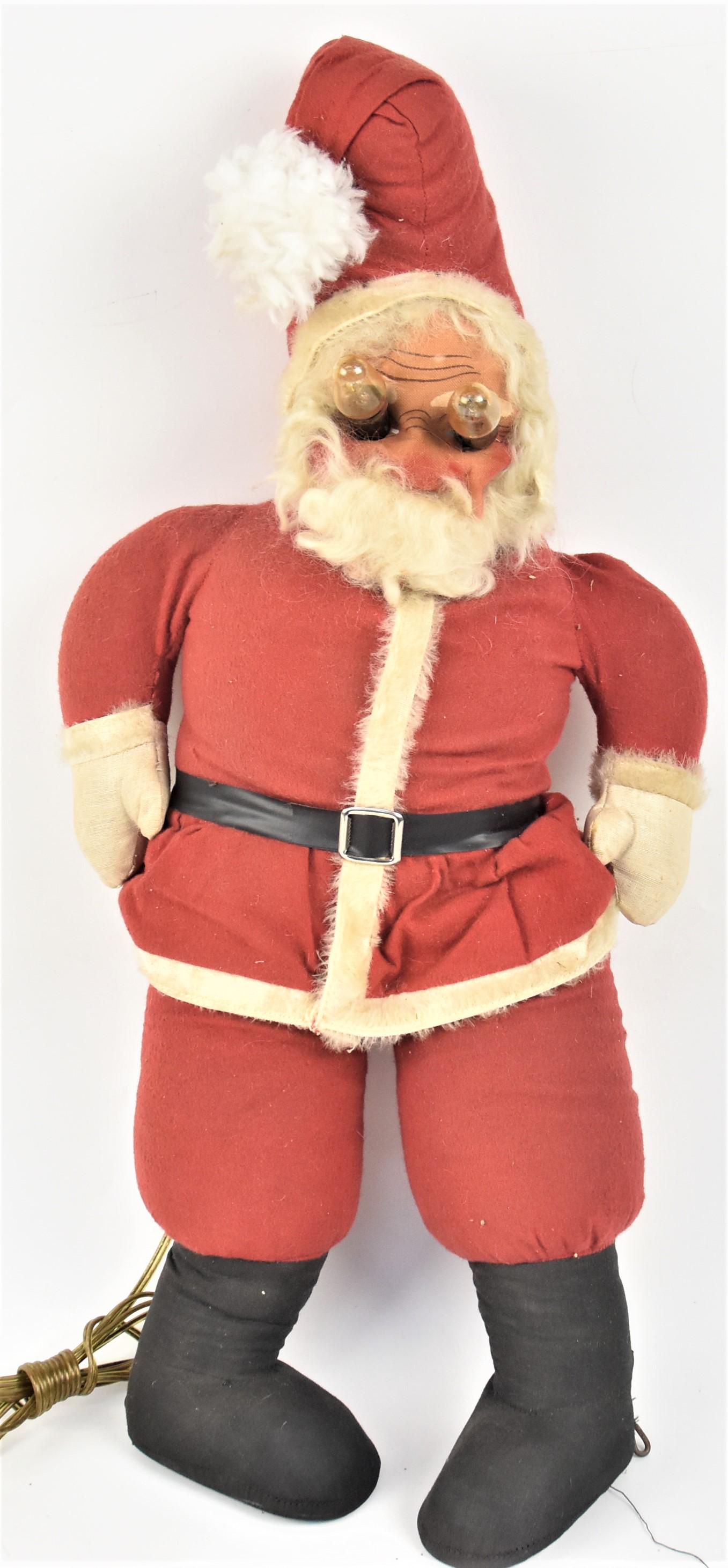 Lighted Cloth Santa: Circa 1940-50s in traditional red fur trimmed suit (fake fur) and cap with black boots, 1940s style Christmas lights mounted as eye molded and painted cloth face, 26" tall. Condition slight fading, VG