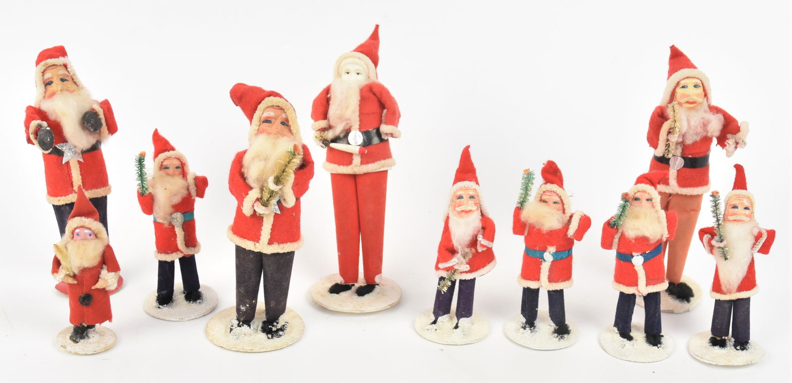 Early Japanese Santas: Lot of ten, five marked Japan or Made In Japan with cello faces and cloth outfits with card stock bases, all holding trees, 4" high; plus 6 1/2" with ghostly cello face holding wood baton; plus four w