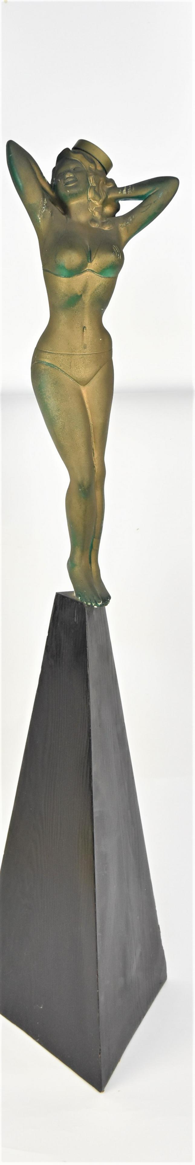 Erotic Stewardess Statue: Cast plastic of circa 1960s stewardess wearing pill box type cap and bikini, mounted on wood triangular base, 45" high. Condition slight wear to finish.