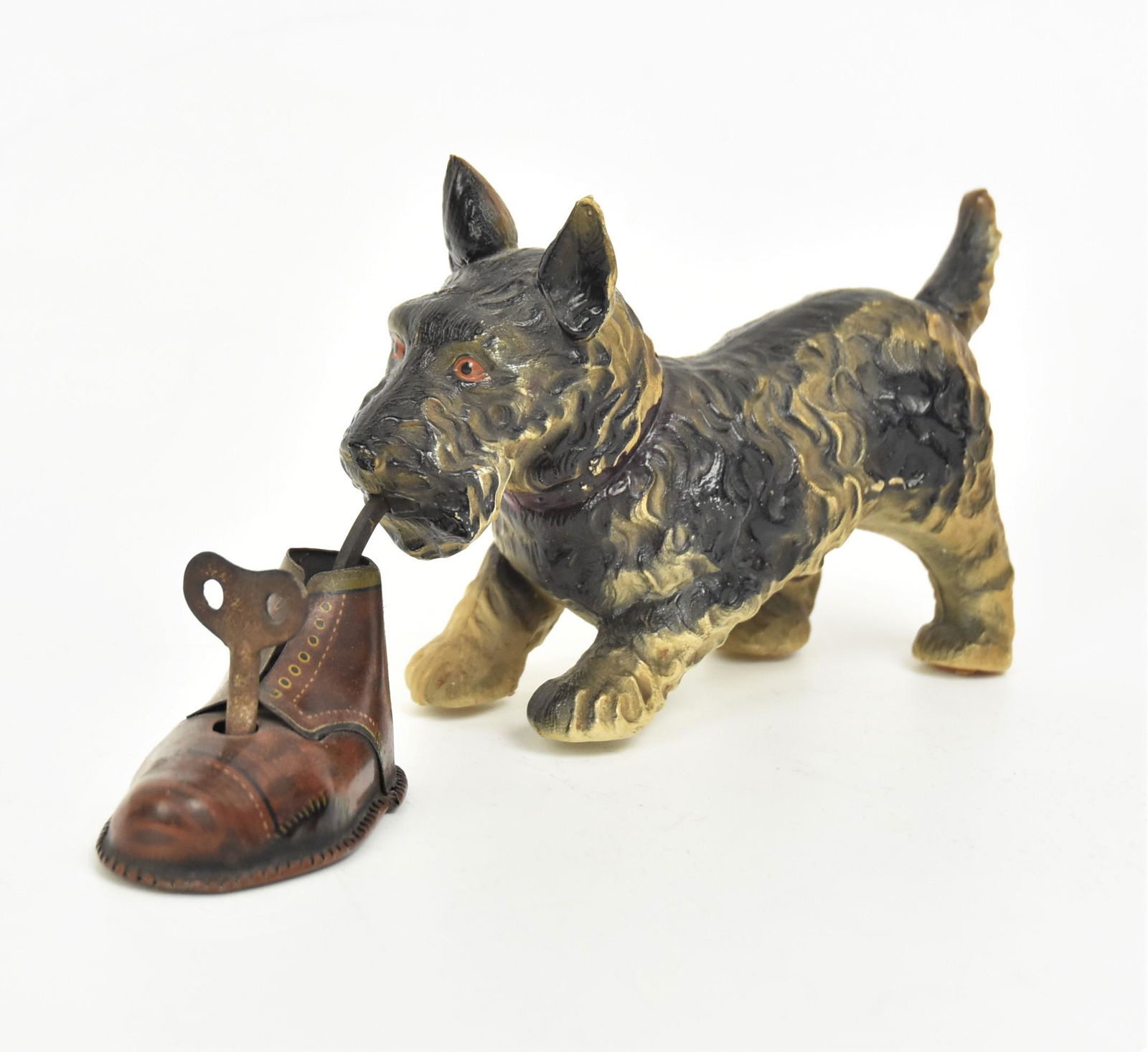 Cello & Tin Dog with Boot Toy: Scotty dog in black and white with red painted eyes standing and worrying a chromolithogrphed tin mans shoe with removeable key, marked on back with rayed sunrise & M.T. Made In Japan (Modern Toys), 8