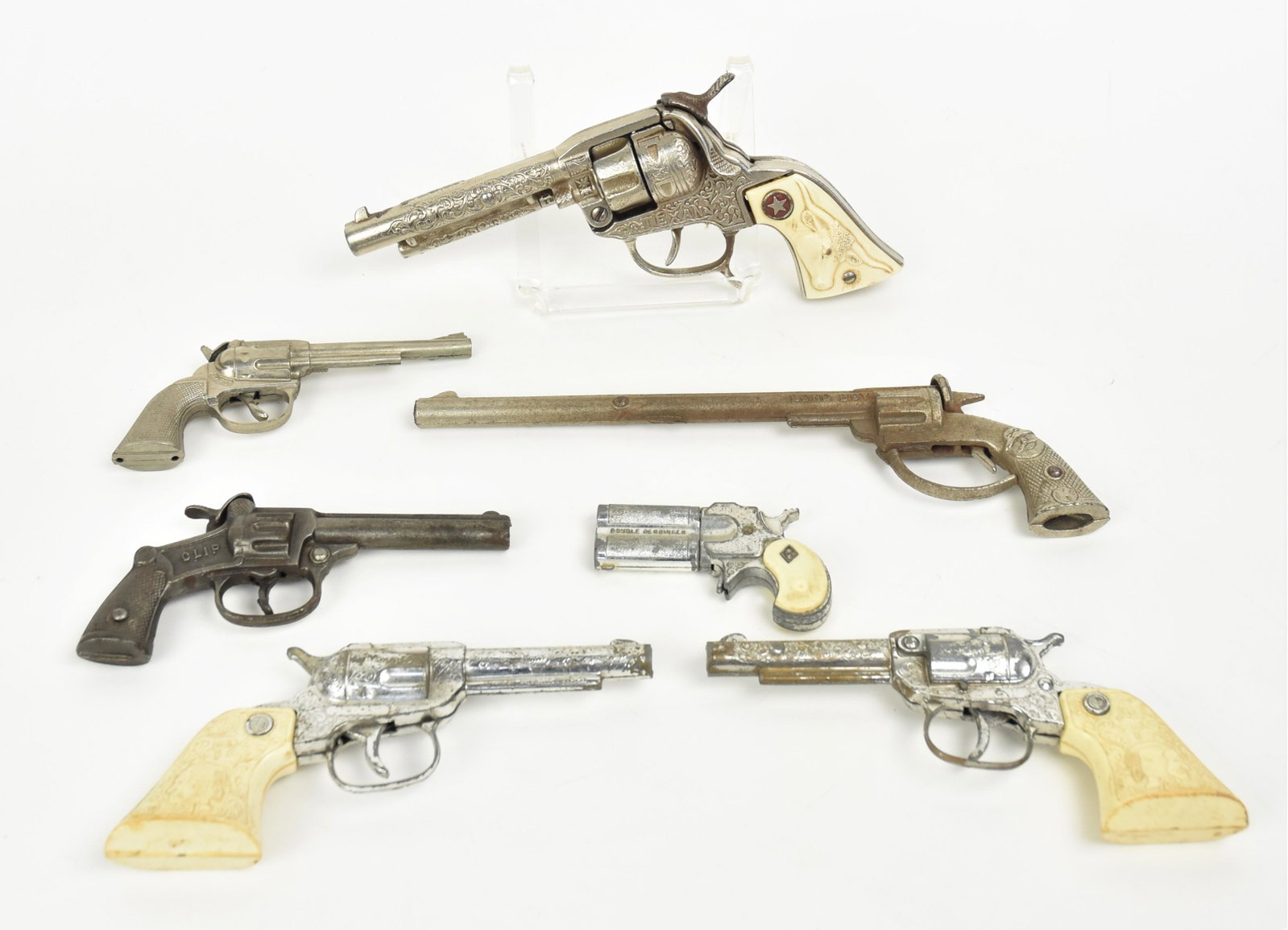 Lot of Early Toy Guns: Lot of seven, including cast iron cap gun marked Clip on each side, likely made by Stevens in natural finish, 6" long; plus cast iron cap gun marked Long Boy by Kilgore in bright finish, 11