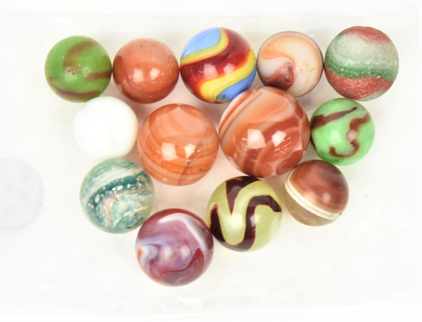 Thirteen Early Marbles: Includes 5 real agates; and 8 early machine made marbles, one with silver mica, 5/8" to 7/8" diameter. Condition one frosted