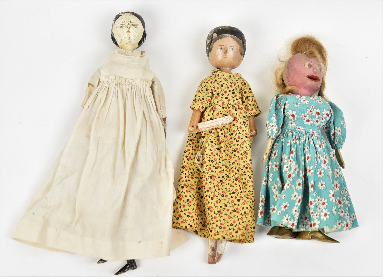 Wooden Penny Dolls: Two are 19th century jointed with painted features and older dressed, 11 1/2 & 12" tall; 3rd is 1st quarter of 20th century folk art doll with rel hair wig, carved & oainted features and original dres