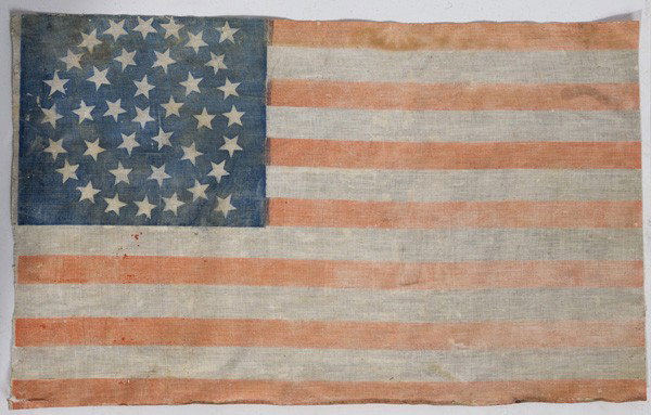 THIRTY-SEVEN STAR U.S. FLAG: Linen with unusual star pattern in canton. Some fading and short tear at hoist. 13.5" x 22".