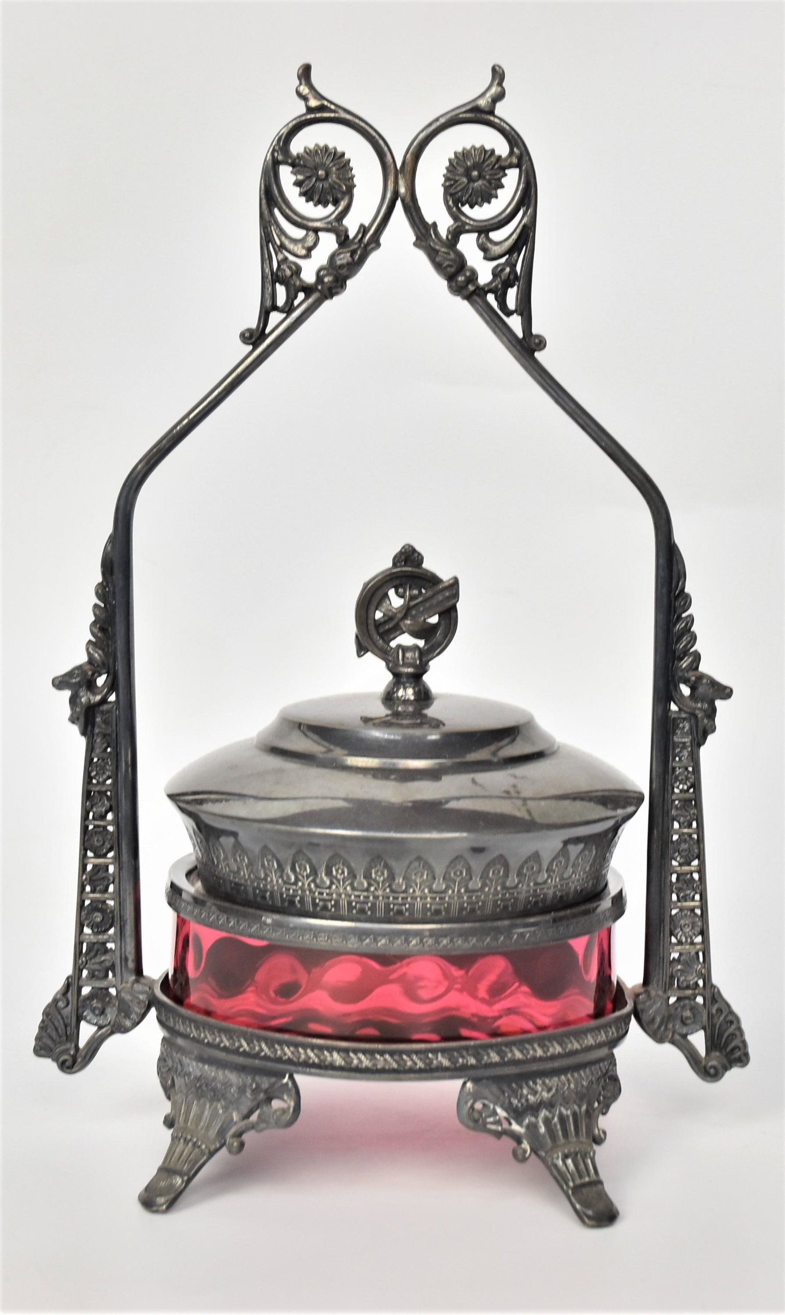 Victorian Cranberry Art Glass Container: Consisting a thumbprint ruby glass insert 5" Dia mounted within Barbour Bros. Co. Quadruple plate ornate frame 12" h. One very very minute flea bite flake on inside rim of insert no harm done otherwis