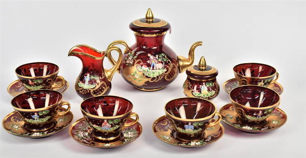 Bohemian Ruby Tea Set: Ornately decorated with enamel landscape and flowers hghlighted with extensive gold applications. Includes a covered tea pot 8"H x 9" W, covered sugar bowl 4 1/52" H x 3 1/2"W, cremer 5 1/4"H, 6 tea
