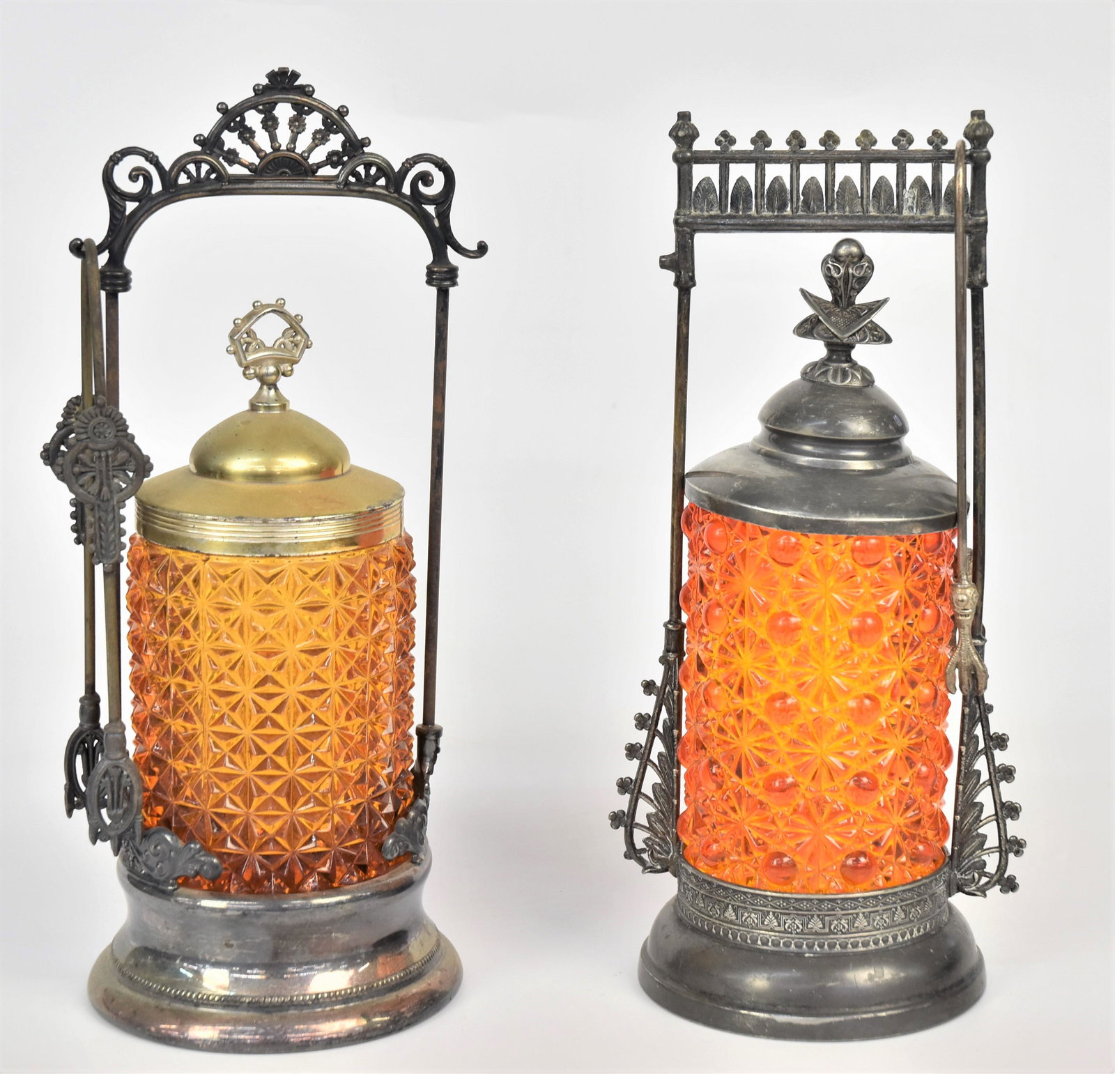 Two Victorian Pressed Pickle Castors: 5" H Orange Daisy & button in Forbes silver Co, 673 1/2 holder with tongs and cover, 4 1/4"H Amber, chips to base in EG Webster Bros, NY hard white metal frame, marked Quadruple plate, with tongs and 