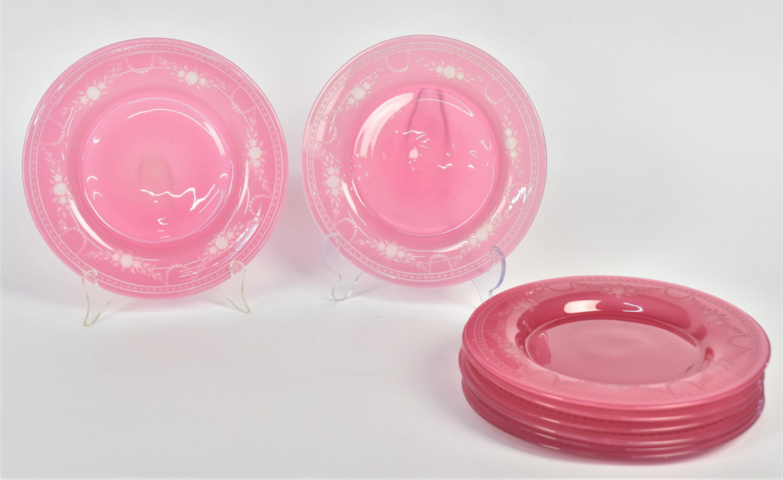 Six Steuben Rosaline Dessert Plates: With wheel engraved floral swags 8 1/2" dia. One has pink flat chip on underside of rim otherwise all in good condition. Decorative set.