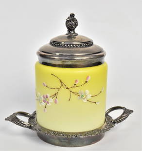 Fancy Victorian Yellow Satin Cracker Barrel: In seldom seen yellow with enamel floral, 6 1/4"x 5" fitted within a Rockford quadruple plate handled tray & with cover. 9" combined height, minor flake to glass rim, otherwise handsome and showy.