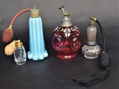 Four Atomizer Perfumes: A 6" cranberry enameled , a 6" blue ribbed with original bulb, a 5" floral enamled plus a 2 3/4" mini clear diamond pattern with original bulb. Good condition.