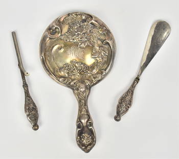 Three Art Nouveau Sterling Dresser Pieces: Including a 10" hand mirror with raised floral, plus an 8" shoe horn and 7 1/2" curling iron. Engraved initials on mirror, else VG.