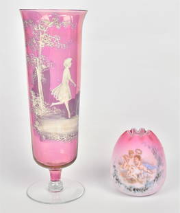 Peachblow Art Glass & Mary Gregory Vase: Lot of two including a tall cranberry Mary Gregory mantle vase with a young lady & a hoop decoration 11 3/4" high; and a satin peachblow rose bowl with cupids and doves 4" high. Condition both VG.