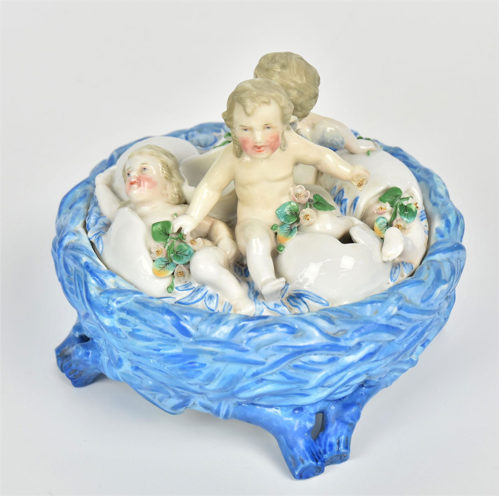 KPM Porcelain Covered Container: With a cover of cupids emering from eggs over a blue nest base, marked, 5" x 6 1/2"diameter. Condition Fine.