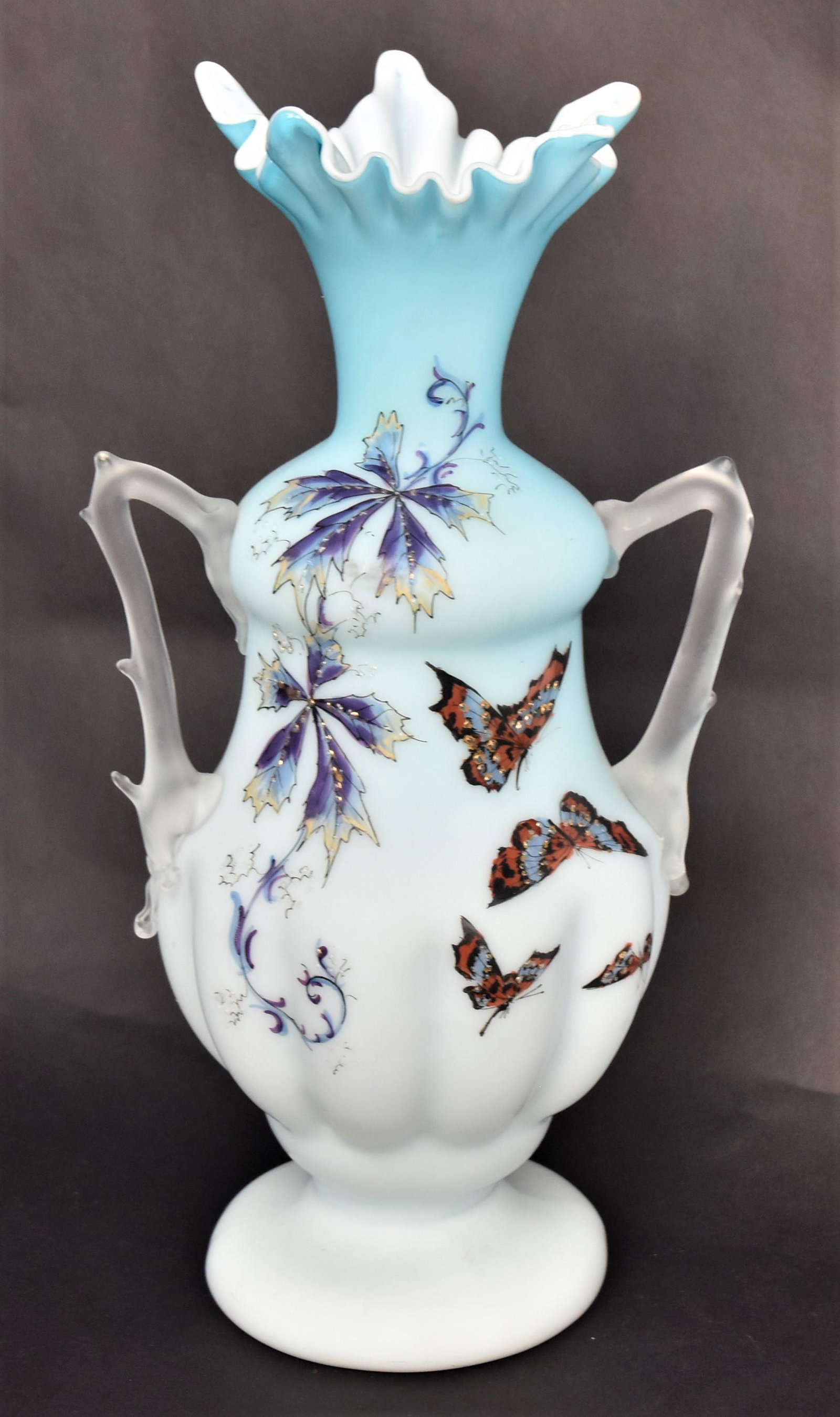 Unusual Blue Satin Vase: Hand enameled with butterflies visiting and woodbine vine. Nice handkerchief rim & frosted thorn handles Height 12 1/2"H, 6 3/4" W from handle to handle. Good condition.