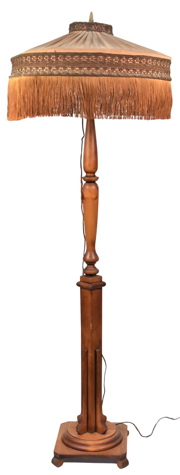 Early Wood Floor Lamp: Electric with turned and square column original fabric shade with hanging silk fringe, 24" diameter x 70" high. The outside fabric of shade is in very good condition, the inside layer of fabric on the