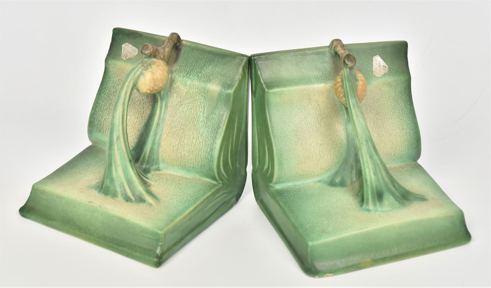 Pair Roseville Pine Cone Bookends: Measures 4 7/8"H, both have silver Roseville stickers, minor glaze nick & glaze skips to one base. Factory fill to upper corner of other.
