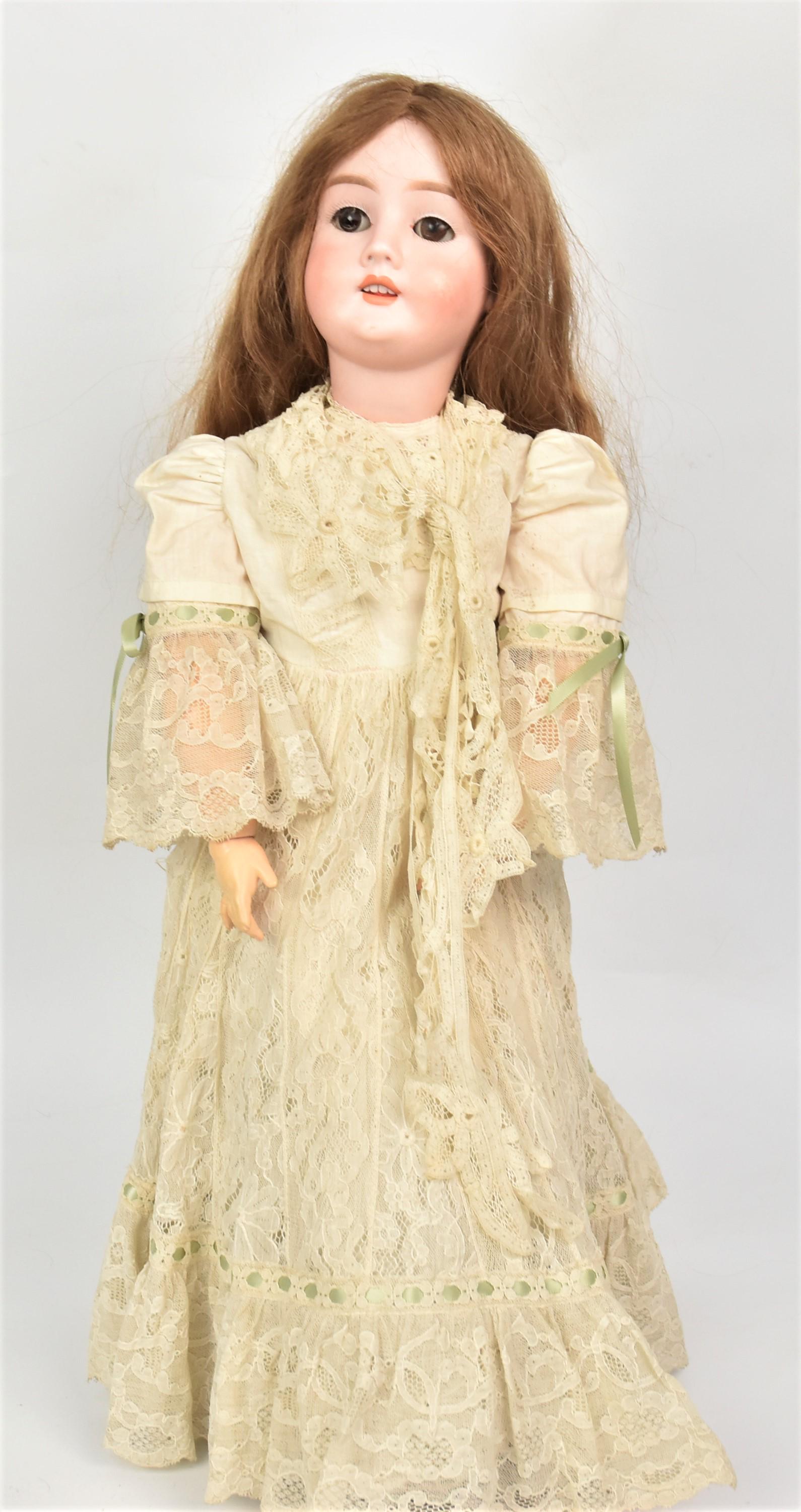 German Bisque Head Doll: Measures 24" H Bisque socket head, marked Special 65 Germany, on jointed composition body, with beautiful original lace dress. All in good condition.