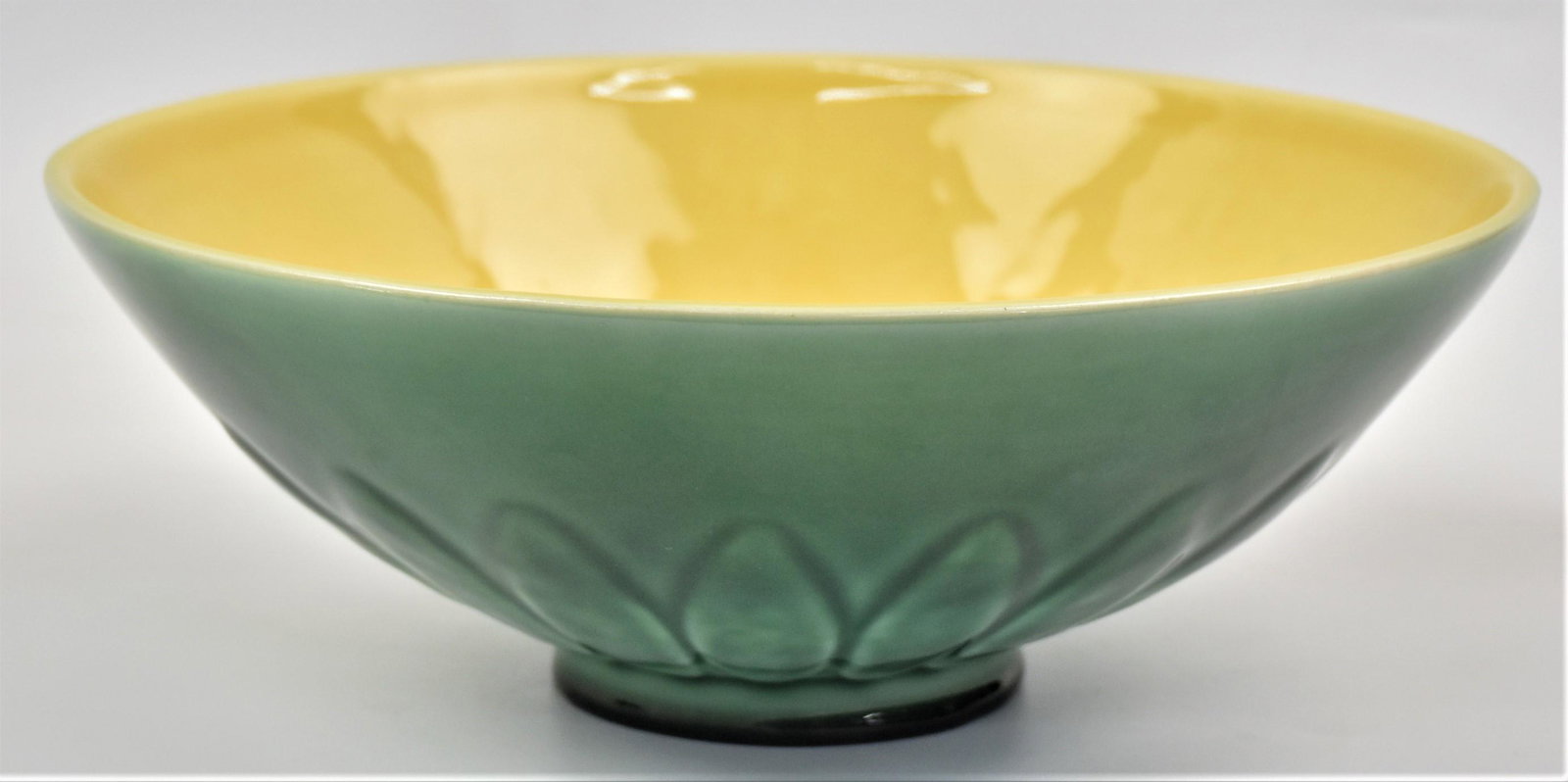 Rookwood Pottery Lotus Flower Center Bowl: Bi-color high glaze, green & yellow with molded lotus flowers around base, marked with Rookwood symbol, dated 1949, shape number 6967, designed by John D. Wareham, 12" diameter x 4 1/2" high. Conditio