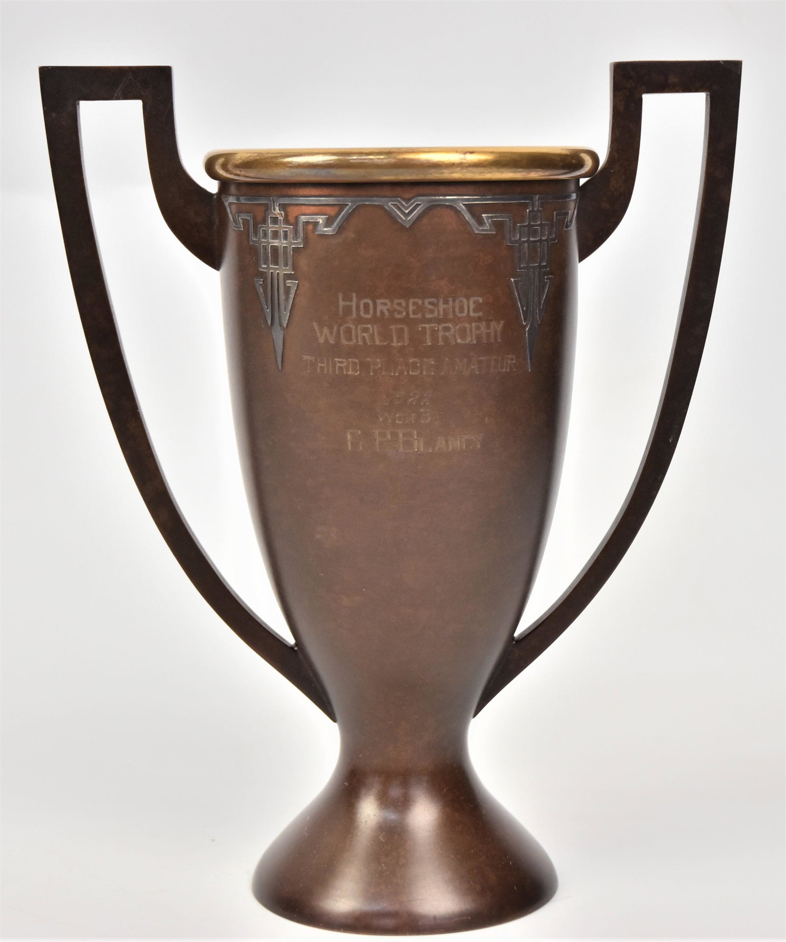 Heintz Bronze & Sterling Trophy: Given for horseshoe pitching with sterling figure of gentleman throwing horseshoe with geometric scroll work, two handles with gilt liner reverse with matching scroll work and engraved inscription: Ho