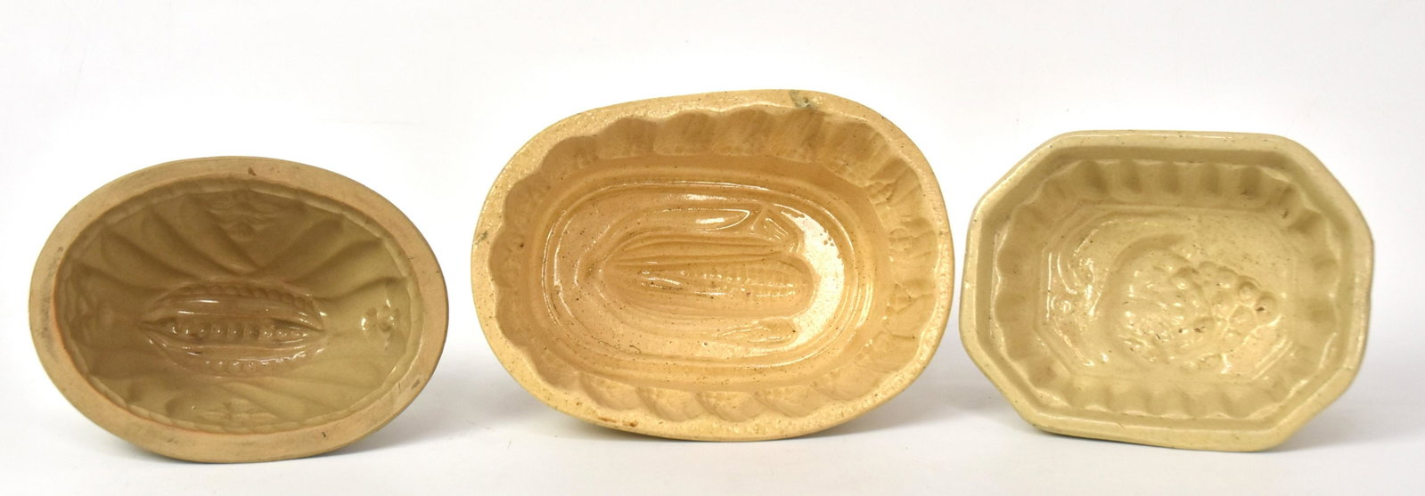 Three Yelloware Molds: Including corn, pea pod, and grapes. Largest is 4"H x 8 1/4" W x 6"D.