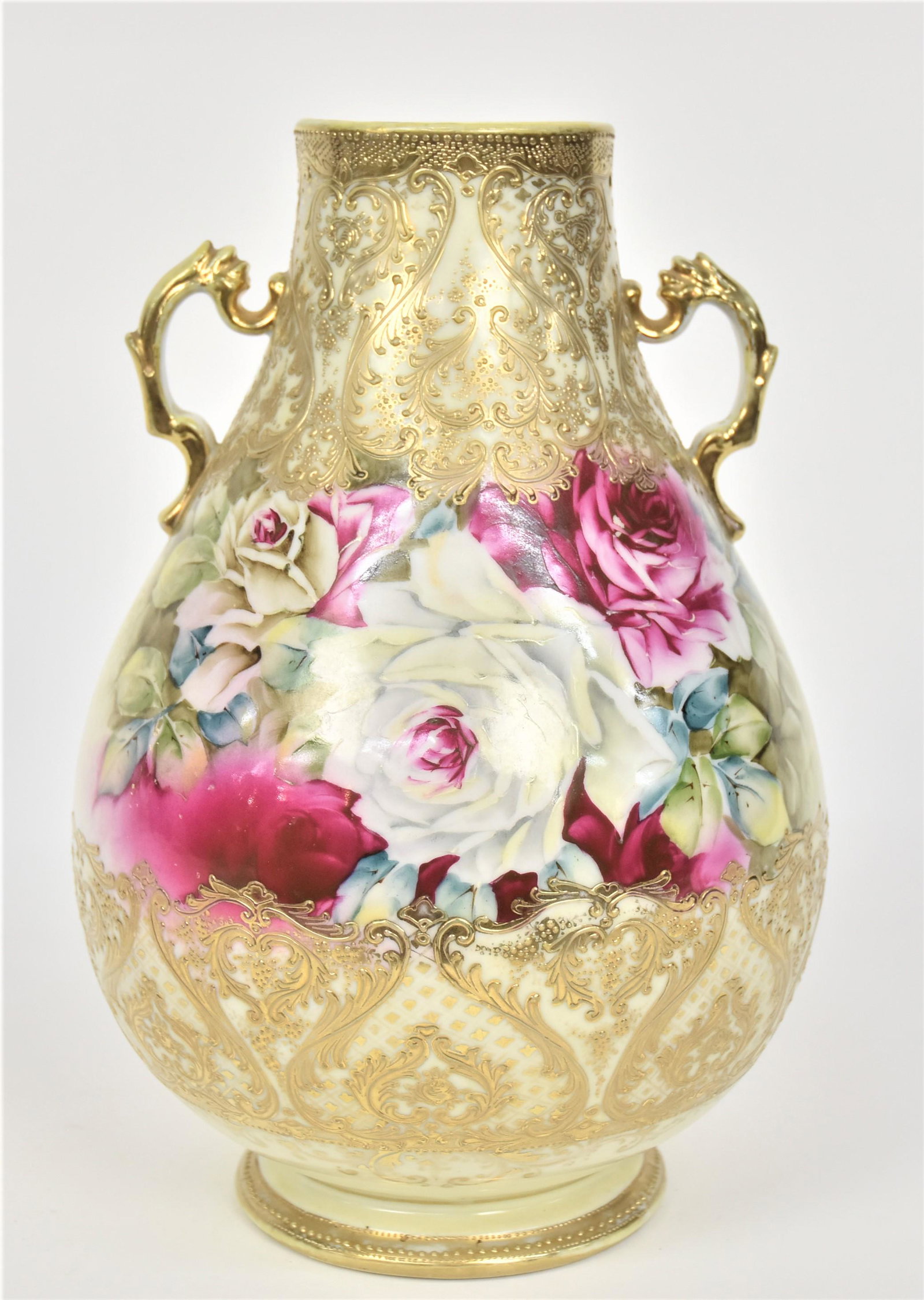 Nippon Sizable Rose Bouquet Vase: With elaborate gold & enamel scroll work. Gold dolphin-like handles. 12”T. 8 1/4”W. Striking vessel. Very good condition. Blue mark.