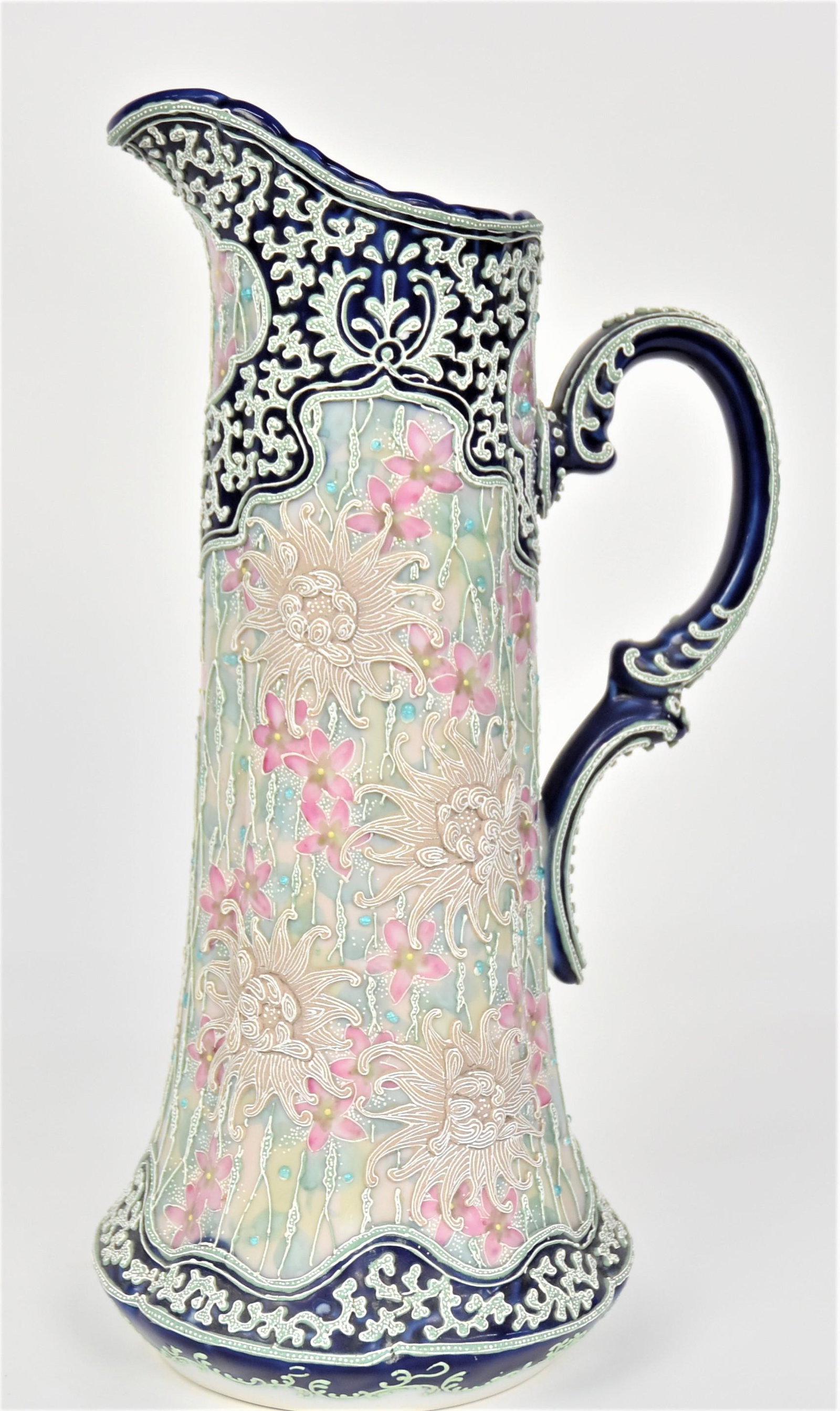 Impressive 15-3/4" Nippon Moriage Cobalt Blue & Jeweled Tankard: Pastel florals embellished by exotic flowers in high relief. 15 3/4”T. 7”W base. Majestic design. Very good condition. Unmarked.