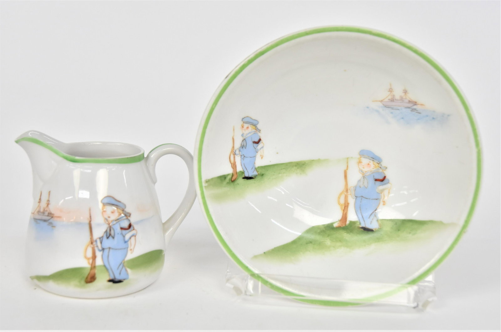 Nippon Childs Set: Consisting a 5 7/8”D cereal bowl and 3”T milk pitcher each has a boy holding a BB rifle decoration. Good condition. Blue mark.