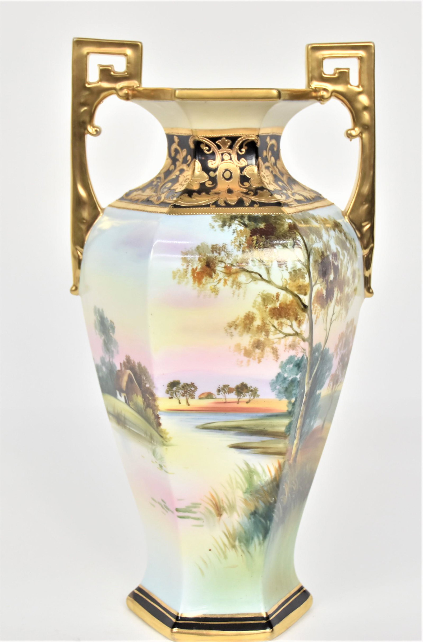 Nippon Tall 14" Hexagonal Landscape Mantle Vase: Colorful fall scape With acoastal home. Decorative gold collar. Pierced gold handles. 13 3/4”T. 6 3/4”across handles. Impressive vessel. Very good condition. Green mark.